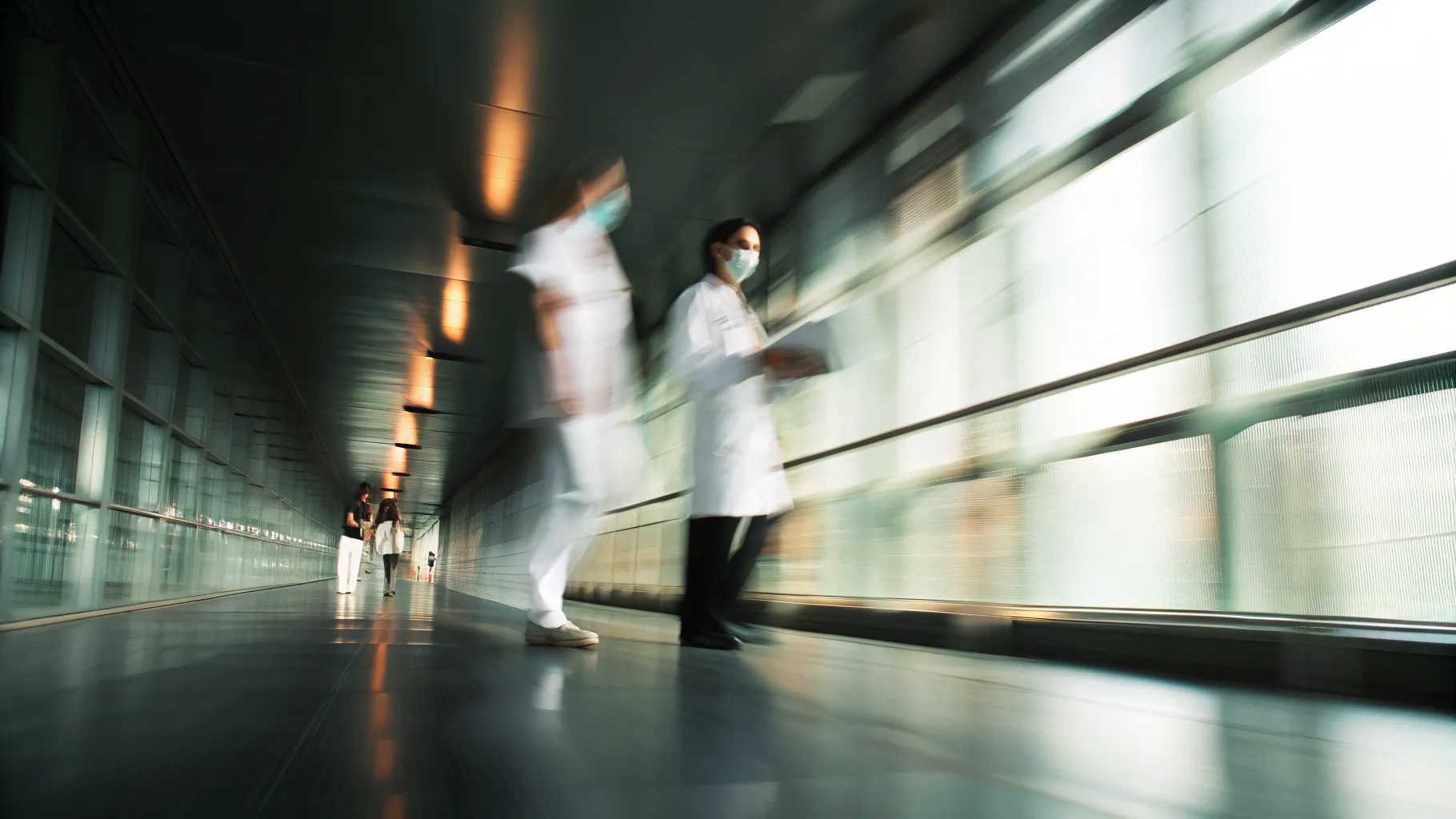 Medical staff walking through a modern hospital corridor